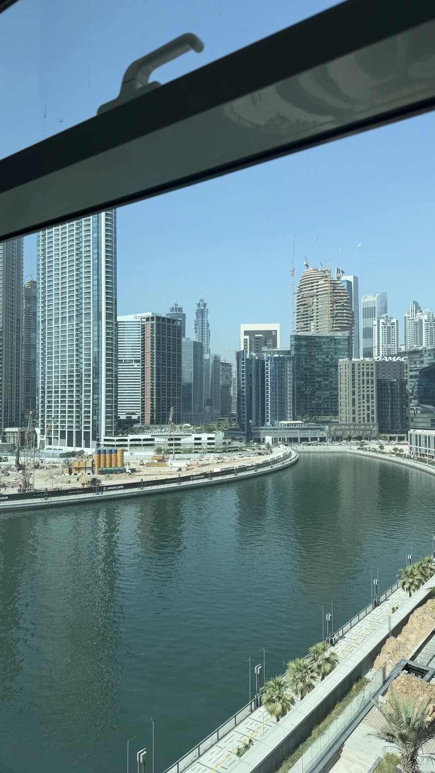 Canal, waterfront walkway and Dubai buildings seen from the office